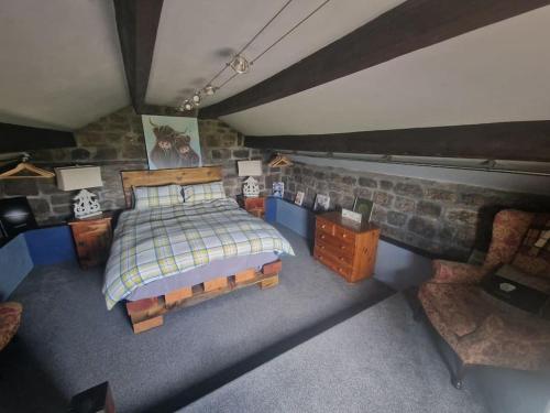 a bedroom with a bed and a stone wall at Cottage incredible views off grid private dog friendly garden cosy in Holmfirth