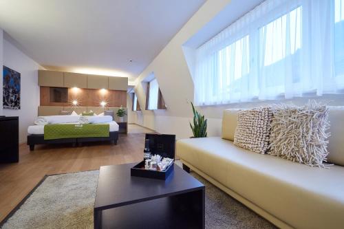 a living room with a couch and a bed at m3Hotel in Sankt Anton am Arlberg
