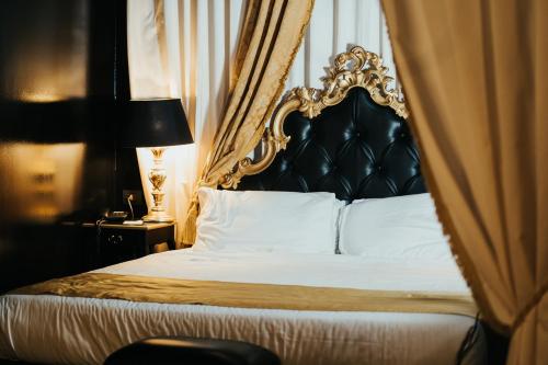 a bedroom with a bed with a black and gold headboard at Emotional Grand Motel in Fontaneto dʼAgogna