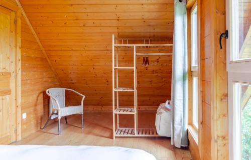 a room with a ladder and a bed in a wooden room at Domaine la Clairière et Bain nordique in Soultzmatt