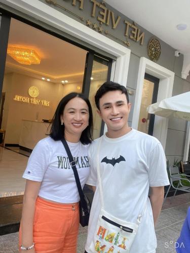 a man and a woman standing in front of a building at Nét Việt Hotel Vincom Sóc Trăng in Soc Trang