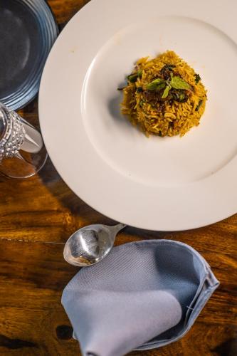 a plate of food on a table with a spoon at Clarks Resort The Archi`s Castle, Ajmer in Ajmer