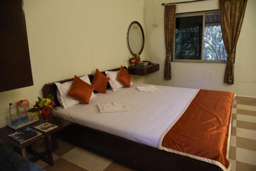 a bedroom with a large bed with pillows and a mirror at Wild Camp- The Nature Resort in Khodāla
