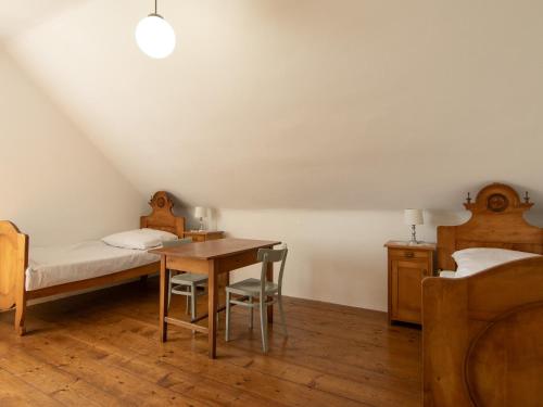a bedroom with a bed and a desk and a bed and a table at The old Village Villa At 2 Geese with Pool in Pišece
