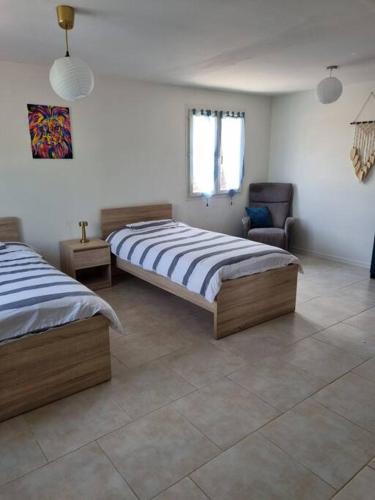 une chambre avec deux lits et une chaise dans l'établissement Villa en Provence, à Pernes-les-Fontaines