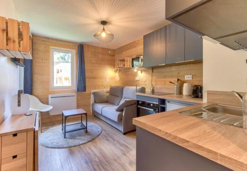 une cuisine et un salon avec un canapé dans l'établissement Ambiance chalet pour 4 - 80m des pistes, à Génos