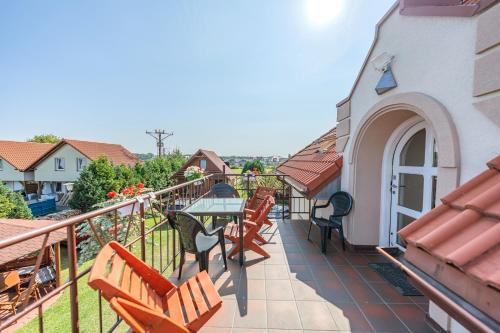 a balcony with wooden chairs and a table on a building at Pensjonat Kwiatkowski apartament nr 4 in Nowęcin