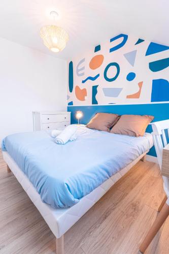 Ce lit se trouve dans une chambre dotée d'un mur bleu et orange. dans l'établissement La Mancelle - 6 Personnes - Plein cœur du Mans, au Mans