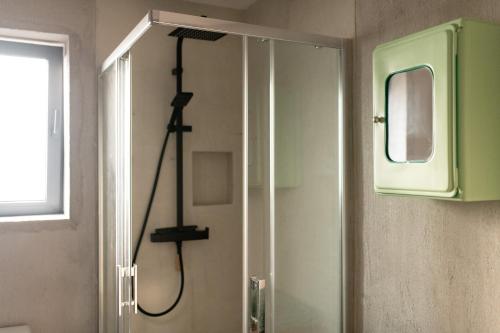 La salle de bains est pourvue d'une douche et d'une fenêtre. dans l'établissement Histoires d'Ault - maison vue mer et jardin, à Ault