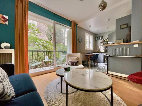 un salon avec un canapé et une table dans l'établissement Superbe Appartement côté Jardin, à Paris