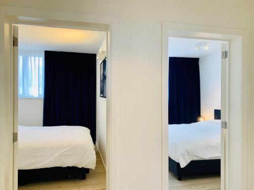 a bedroom with two beds and a mirror at Belfort Shortstay in Ghent