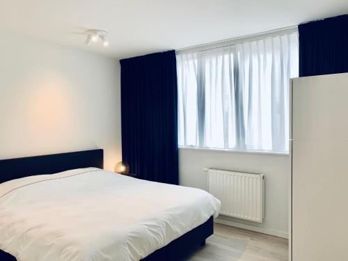 a bedroom with a bed and a large window at Belfort Shortstay in Ghent
