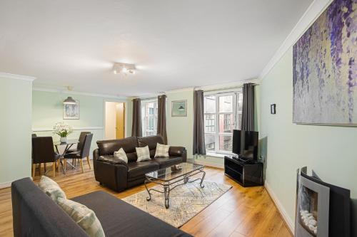 a living room with a couch and a tv at Bookbinders Apartments Leeds City Centre in Leeds