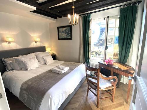 une chambre avec un lit et un bureau avec une chaise dans l'établissement Nid douillet au cœur de Paris, à Paris