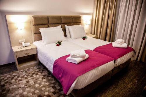 a hotel room with a large bed with towels on it at Filokalia Hotel in Ioannina