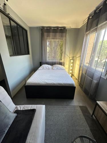 une chambre avec un grand lit et une fenêtre dans l'établissement STUDIO JACCUZZI A 2 Min dAvignon, aux Angles (Gard)