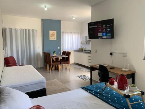 a room with a bed and a kitchen with a table at Studio 21 Fácil acesso Aeroporto Internacional Guarulhos e Arena Corinthians in Sao Paulo