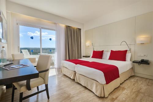 a hotel room with a large bed and a desk at Grupotel Taurus Park in Playa de Palma
