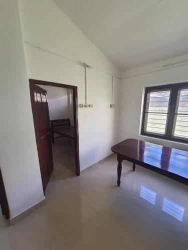 a room with a table and a door and a window at Serenity in Trivandrum
