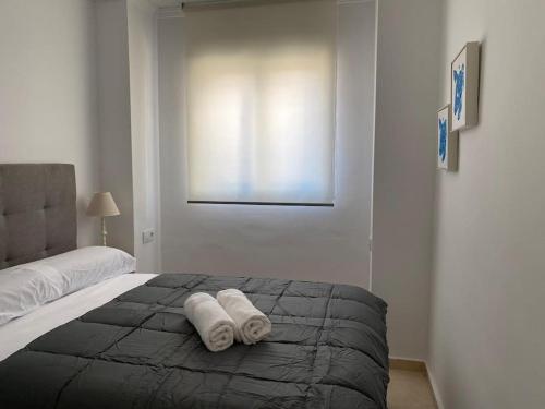 a bedroom with a bed with two towels on it at Edifico Mañez Segundo- Nuevo, 10 minutos Gibraltar in La Línea de la Concepción
