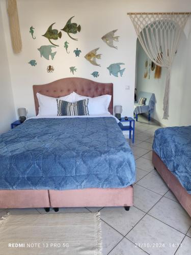 a bedroom with a bed with fishes on the wall at Mana mia Seaside Apartments in Leptokaria