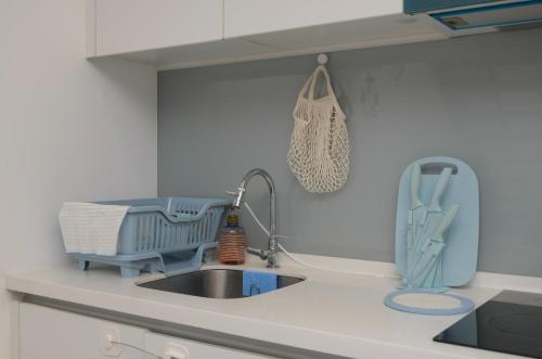 a kitchen counter with a sink and a drying rack at Ekocheras Cozy Loft in Kuala Lumpur