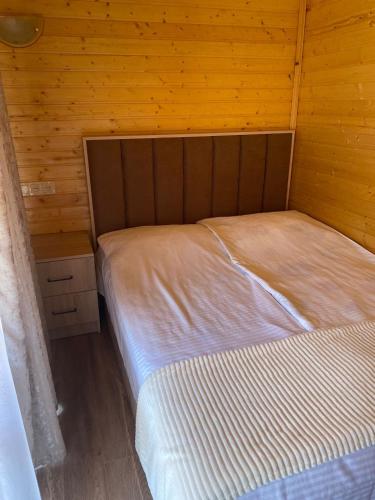 a bedroom with a bed in a wooden room at Dililuxe Hotel in Dilijan