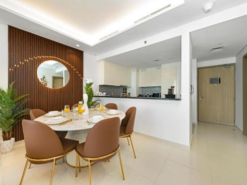 a dining room with a table and chairs and a mirror at Stunning 2BR with Burj View & Infinity Pool in Dubai
