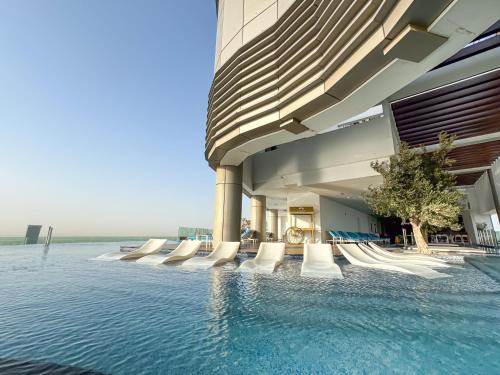 a building with a swimming pool next to the water at Stunning 2BR with Burj View & Infinity Pool in Dubai