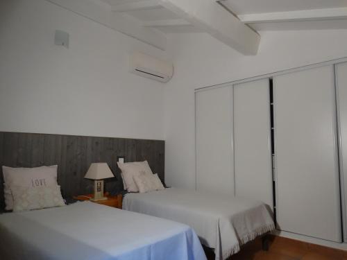 Cette chambre blanche dispose de deux lits et d'une fenêtre. dans l'établissement Les Routes, à Propriano