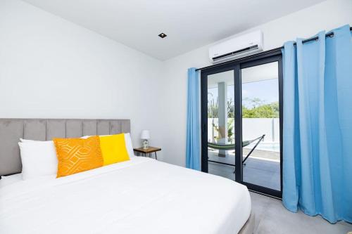 a bedroom with a bed and a sliding glass door at NEW Luxury 5BR Villa - Casa Graziano by Bocobay in Oranjestad