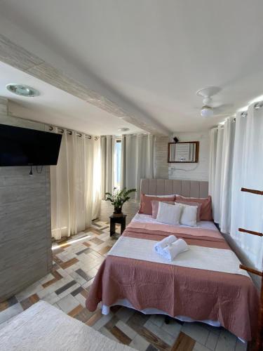 a bedroom with two beds and a flat screen tv at Apêzinho Vidigal - RJ in Rio de Janeiro