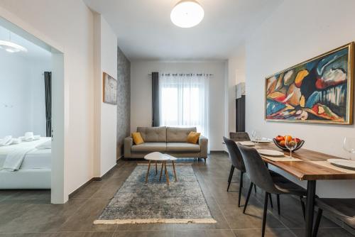 Royal Hill Apartments by PS في دوريس: غرفة معيشة بها طاولة وأريكة