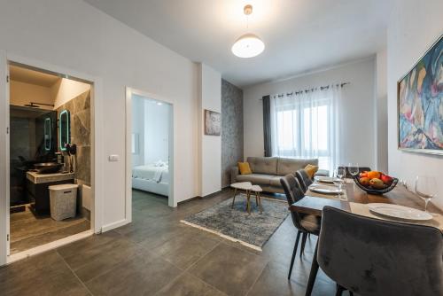 Royal Hill Apartments by PS في دوريس: غرفة معيشة مع طاولة طعام وغرفة معيشة