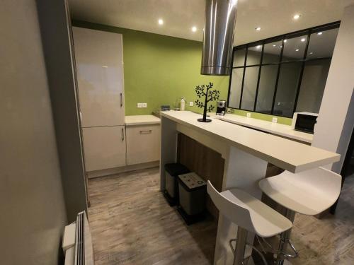 une cuisine avec un comptoir et des tabourets blancs dans l'établissement Le Solférino, cosy town centre with car park, à Poitiers