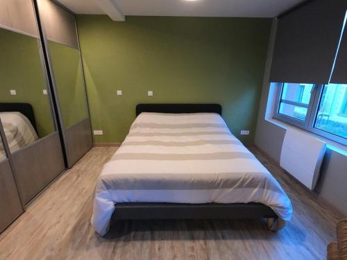 - un grand lit dans une chambre aux murs verts dans l'établissement Le Solférino, cosy town centre with car park, à Poitiers