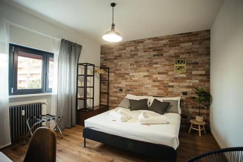 a bedroom with a large bed with a brick wall at The Brick 194, 7 posti letto in Udine