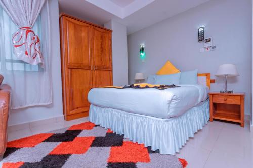 a bedroom with a large bed and a wooden cabinet at Selig Hotel in Moshi