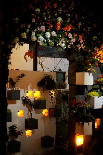 a wall with flowers and candles and lights at Party House in Baisha