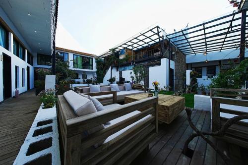 a patio with couches and tables on a building at Party House in Baisha