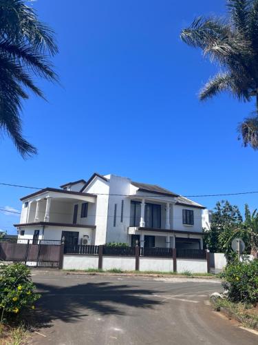 a white house with a fence and palm trees at Teisha House in Souillac