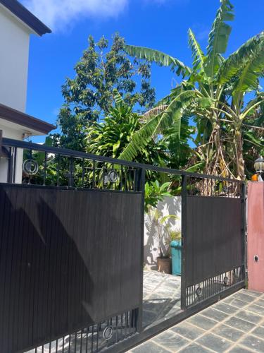 a black gate in front of a house with trees at Teisha House in Souillac