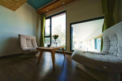 a living room with two chairs and a coffee table at Party House in Baisha