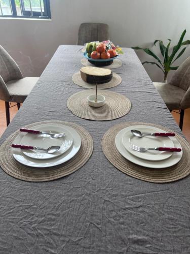 a table with two white plates and a bowl of fruit at Teisha House in Souillac