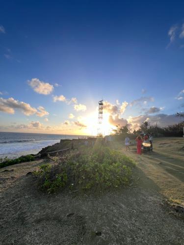 a group of people walking on the beach at sunset at Teisha House in Souillac