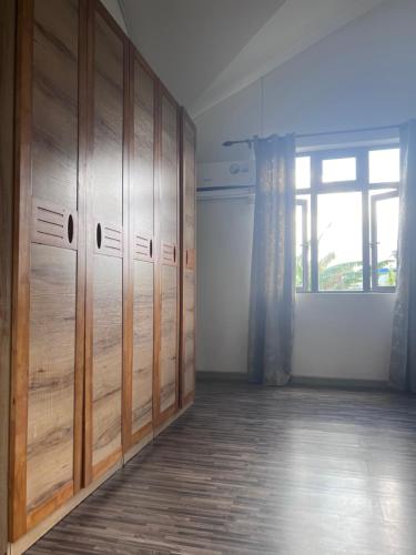 an empty room with wooden lockers and a window at Teisha House in Souillac