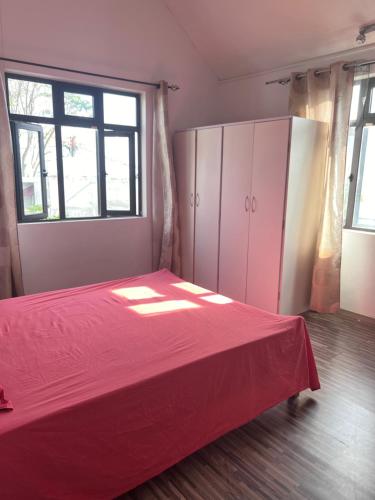 a bedroom with a red bed and a window at Teisha House in Souillac