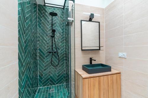 une salle de bain avec une douche avec un lavabo et un miroir dans l'établissement Calm and cozy flat - Central location, à Paris