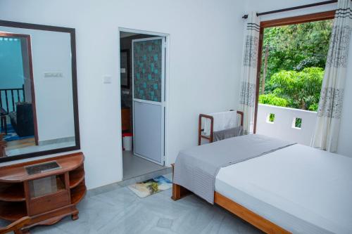 a bedroom with a bed and a large window at VDN House in Kalegana