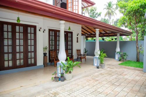 a porch of a house with chairs and plants at VDN House in Kalegana